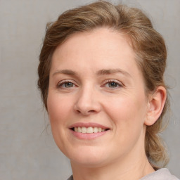 Joyful white young-adult female with medium  brown hair and blue eyes