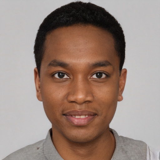 Joyful black young-adult male with short  black hair and brown eyes