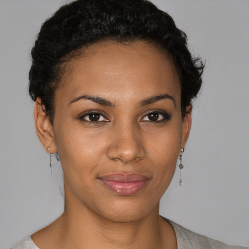 Joyful black young-adult female with short  black hair and brown eyes