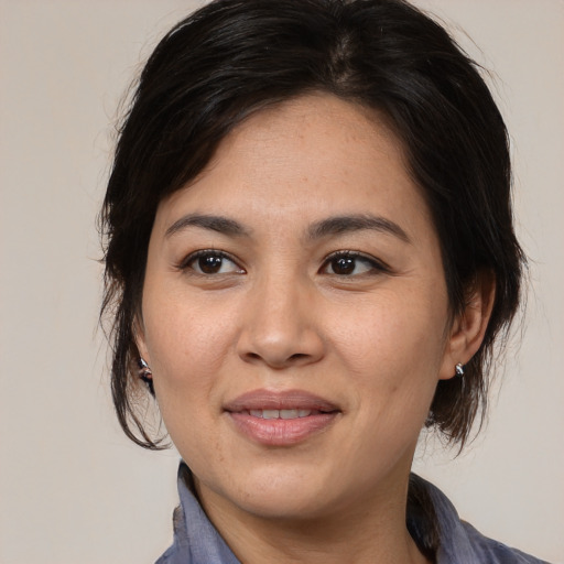 Joyful asian adult female with medium  brown hair and brown eyes