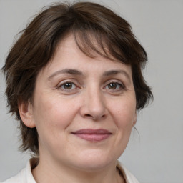 Joyful white adult female with medium  brown hair and brown eyes