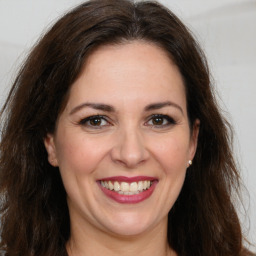 Joyful white adult female with long  brown hair and brown eyes