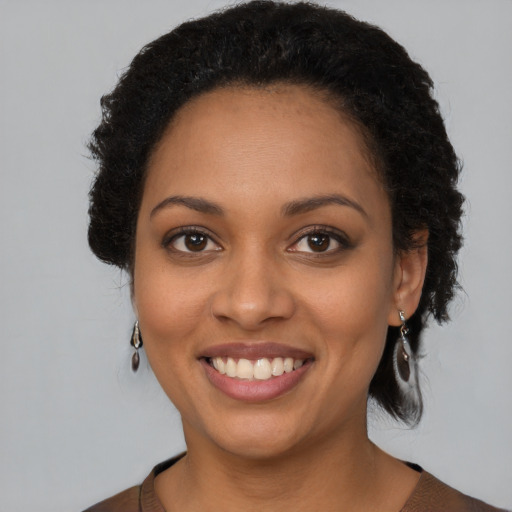 Joyful black young-adult female with short  brown hair and brown eyes