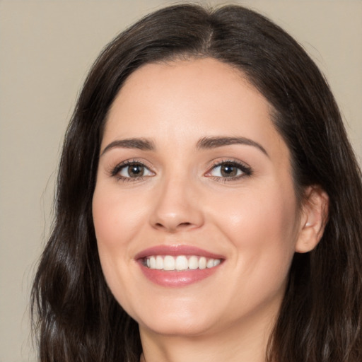 Joyful white young-adult female with long  brown hair and brown eyes