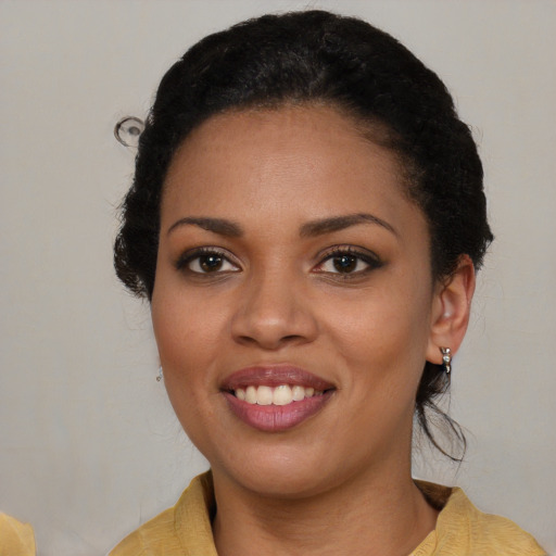 Joyful black young-adult female with medium  brown hair and brown eyes