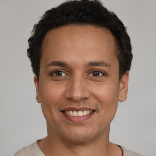 Joyful latino young-adult male with short  brown hair and brown eyes