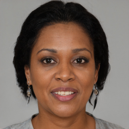 Joyful black adult female with medium  brown hair and brown eyes