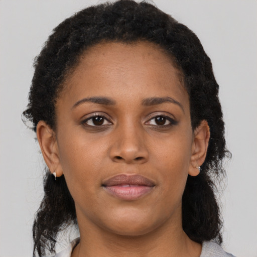 Joyful black young-adult female with medium  brown hair and brown eyes