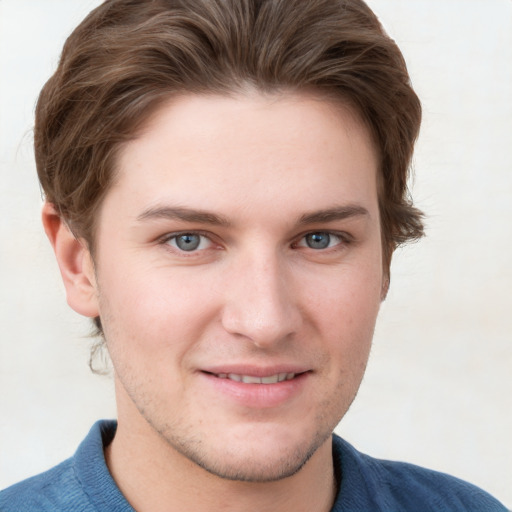 Joyful white young-adult male with short  brown hair and blue eyes