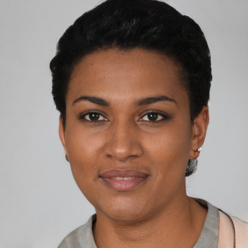 Joyful black young-adult female with short  black hair and brown eyes