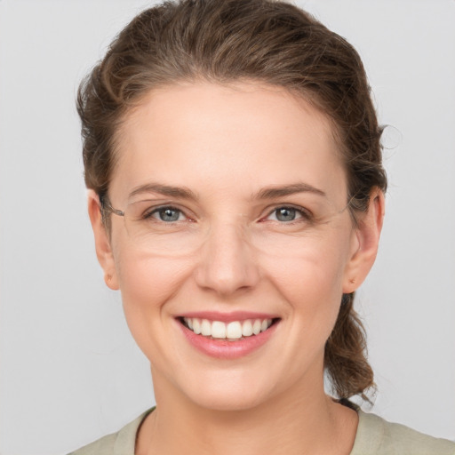 Joyful white young-adult female with medium  brown hair and grey eyes