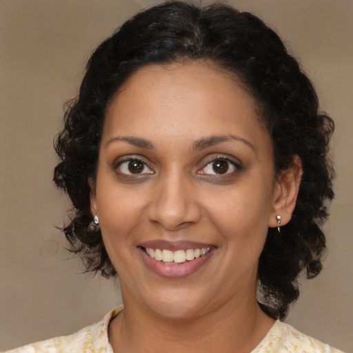 Joyful black young-adult female with medium  brown hair and brown eyes