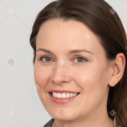 Joyful white adult female with medium  brown hair and grey eyes