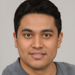 Joyful latino young-adult male with short  brown hair and brown eyes