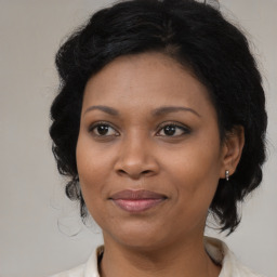 Joyful black adult female with medium  brown hair and brown eyes