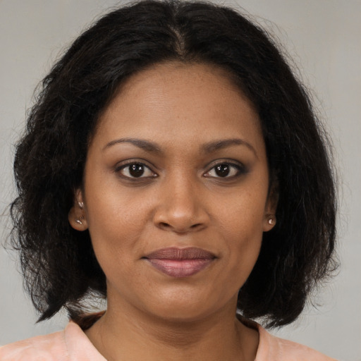 Joyful black young-adult female with medium  brown hair and brown eyes
