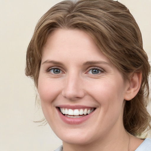 Joyful white young-adult female with medium  brown hair and green eyes