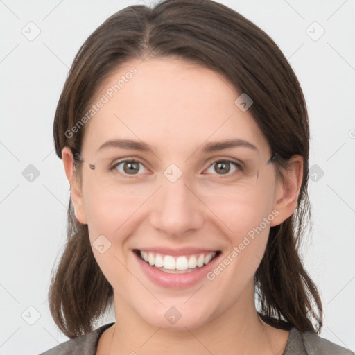 Joyful white young-adult female with medium  brown hair and grey eyes