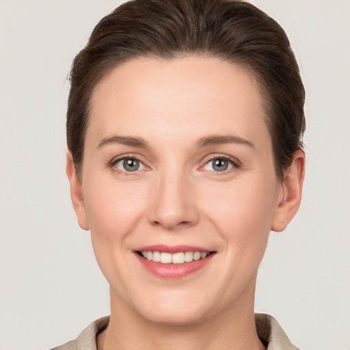 Joyful white young-adult female with short  brown hair and grey eyes