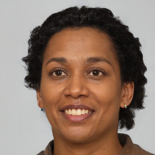Joyful black adult female with short  black hair and brown eyes