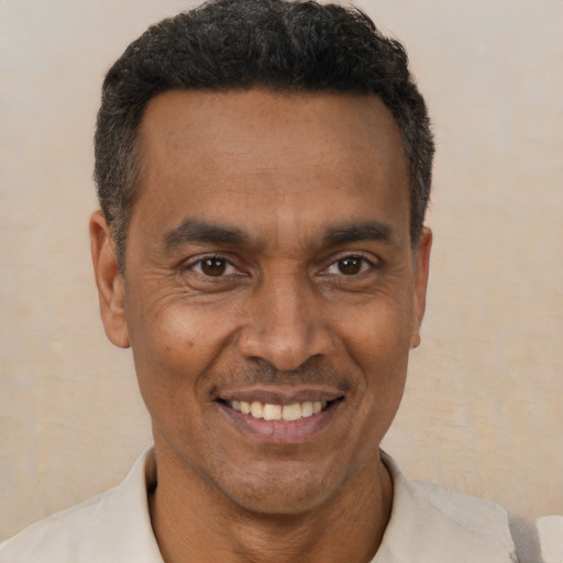 Joyful black adult male with short  brown hair and brown eyes