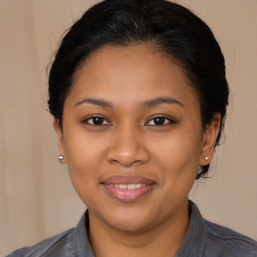 Joyful black young-adult female with medium  brown hair and brown eyes