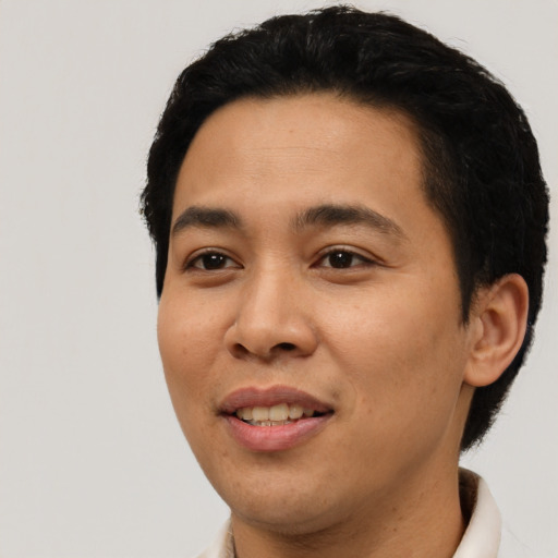 Joyful latino young-adult male with short  black hair and brown eyes