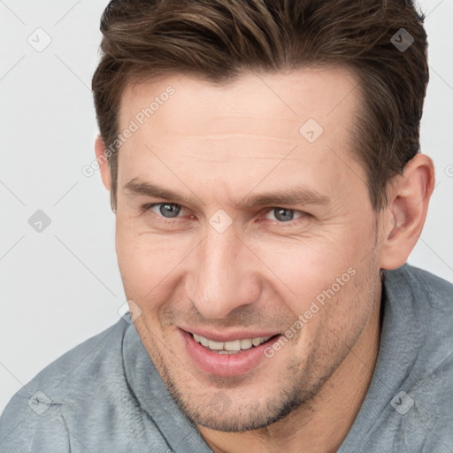 Joyful white adult male with short  brown hair and brown eyes