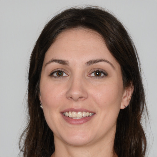 Joyful white young-adult female with long  brown hair and brown eyes