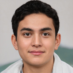 Joyful white young-adult male with short  black hair and brown eyes