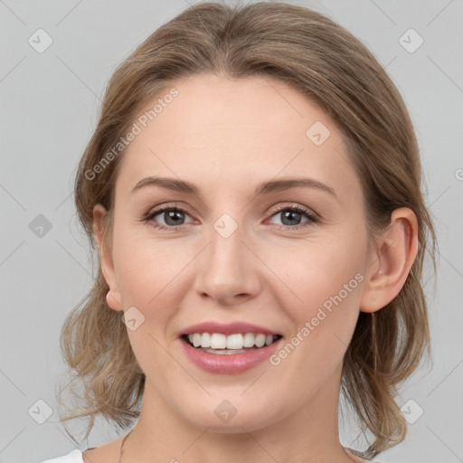 Joyful white young-adult female with medium  brown hair and grey eyes