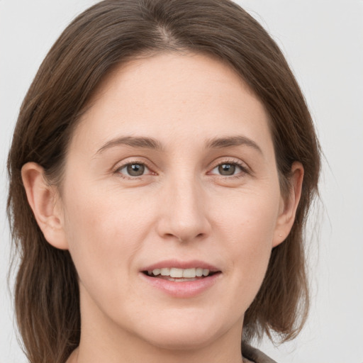 Joyful white young-adult female with long  brown hair and grey eyes