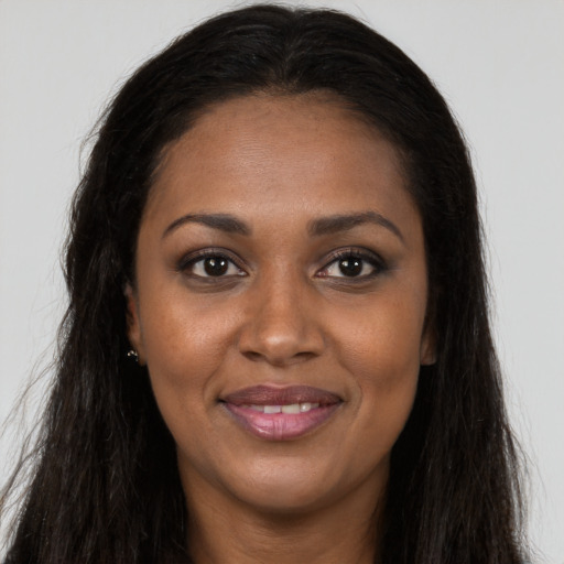 Joyful black young-adult female with long  brown hair and brown eyes