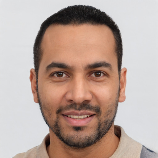Joyful latino young-adult male with short  black hair and brown eyes