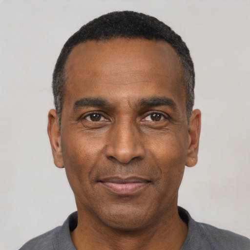 Joyful black adult male with short  black hair and brown eyes