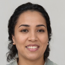 Joyful latino young-adult female with medium  brown hair and brown eyes