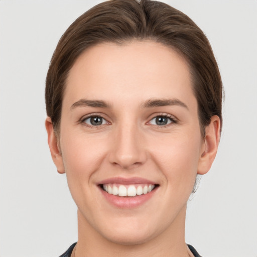 Joyful white young-adult female with short  brown hair and grey eyes