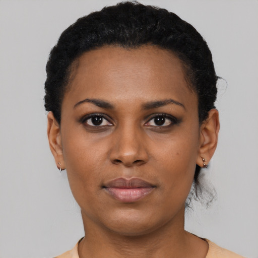 Joyful black young-adult female with short  black hair and brown eyes