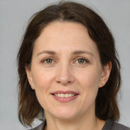 Joyful white adult female with medium  brown hair and grey eyes