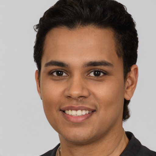 Joyful latino young-adult male with short  black hair and brown eyes