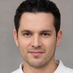 Joyful white young-adult male with short  black hair and brown eyes