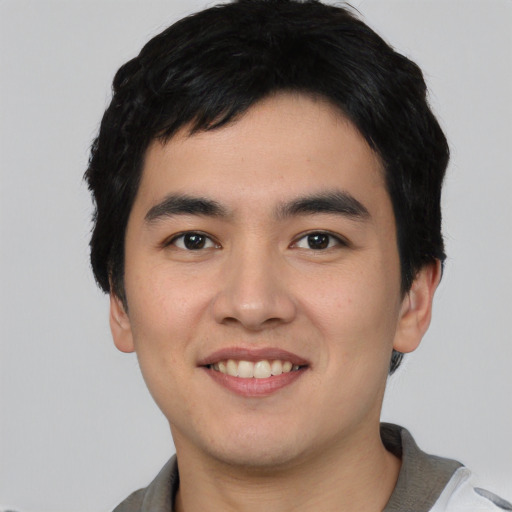 Joyful asian young-adult male with short  black hair and brown eyes
