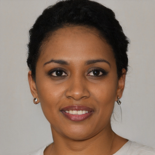 Joyful black young-adult female with short  black hair and brown eyes