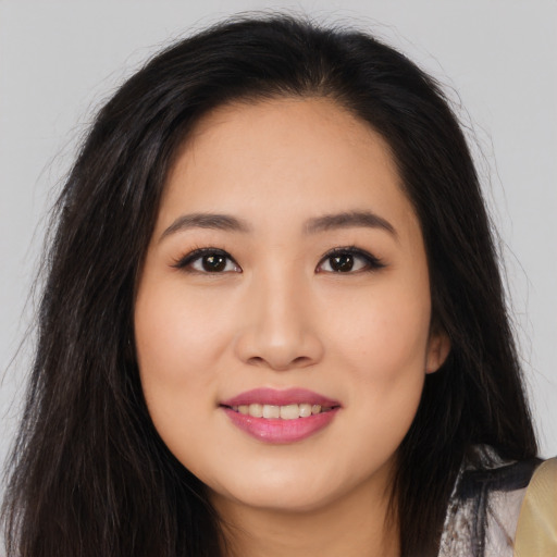 Joyful asian young-adult female with long  brown hair and brown eyes