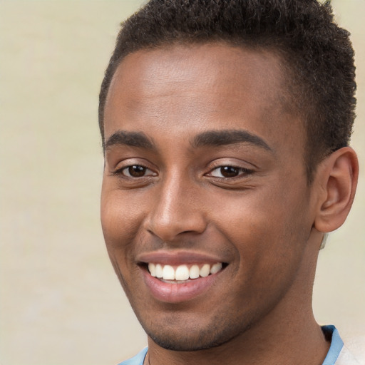 Joyful black young-adult male with short  brown hair and brown eyes