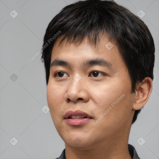 Joyful asian young-adult male with short  black hair and brown eyes