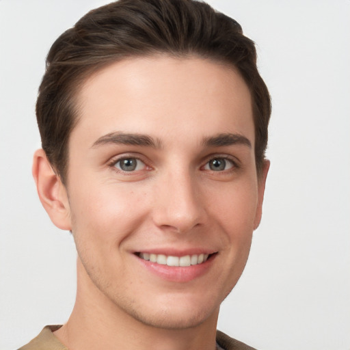 Joyful white young-adult male with short  brown hair and grey eyes