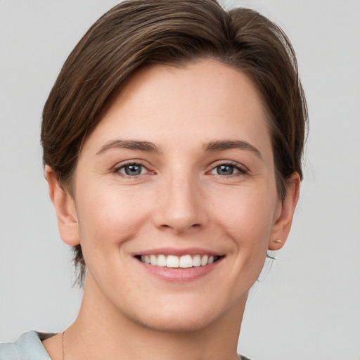 Joyful white young-adult female with short  brown hair and grey eyes