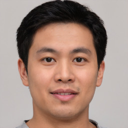 Joyful asian young-adult male with short  brown hair and brown eyes