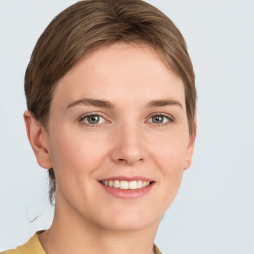 Joyful white young-adult female with short  brown hair and grey eyes